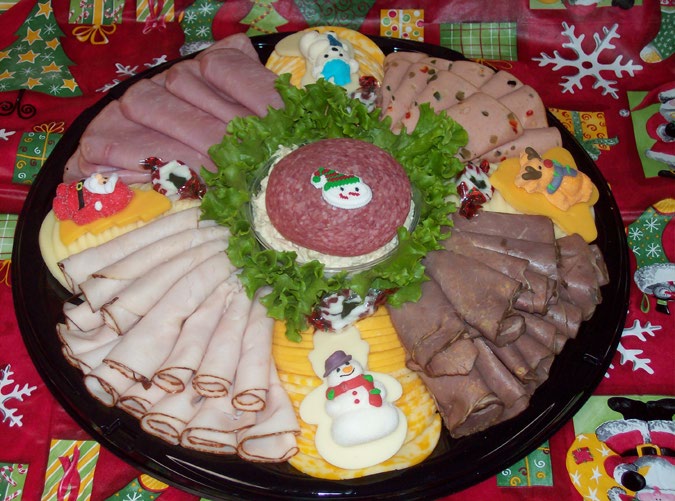 Meat and cheese tray with rolled honey ham, turkey breast, roast beef and salami around a center of lettuce and salad